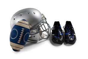 High angle view of American football with sports shoes and helmet against white background