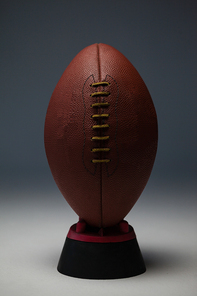 American football on tee against gray background