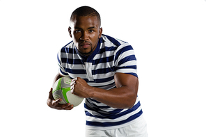 Portrait of young sportsman with ball running while playing rugby against white background