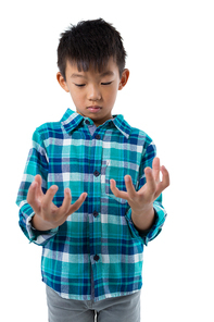 Boy pretending to hold invisible object against white background