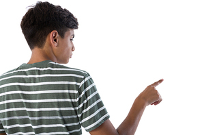 Rear view of teenage boy pressing an invisible virtual screen against white background