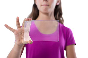 Mid-section of teenage girl using glass digital tablet against white background