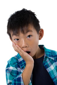 Portrait of astonished boy standing against white background