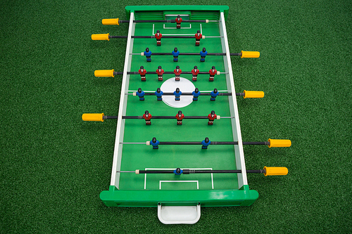 Table soccer game arranged on artificial grass