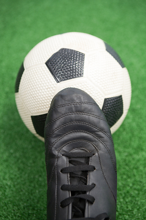 Close-up of football and cleats on artificial grass