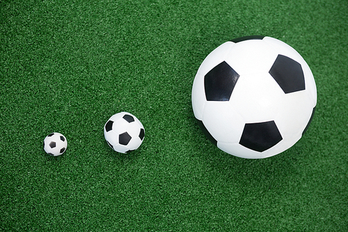 Close-up of various size of footballs on artificial grass