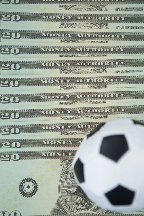 Close-up of footballs on a currency notes