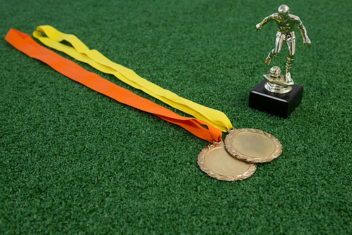 Close-up of trophy and medals on artificial grass