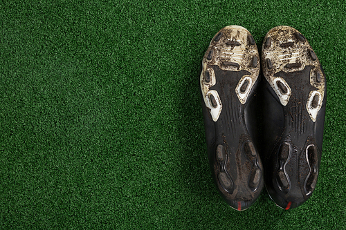 Close-up of cleats kept upside down on artificial grass