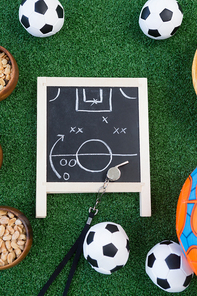 Overhead view of strategy board, whistle and football on artificial grass