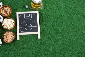 Overhead view of strategy board, whistle and snacks on artificial grass