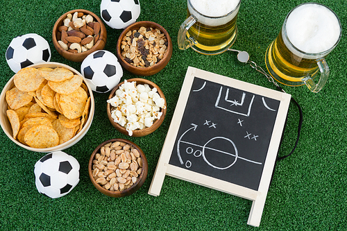 Close-up of strategy board, football and snacks on artificial grass