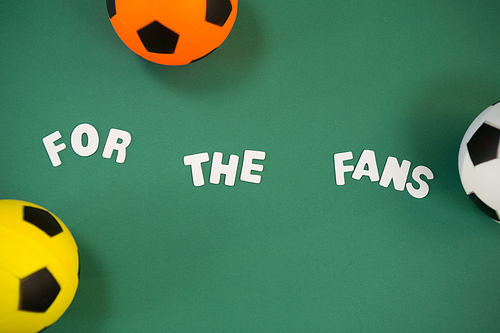 Overhead view of footballs and for the fans text on green background