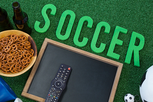 Close-up of chalkboard, snacks and football on artificial grass