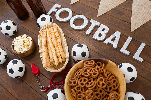 Close-up of football text and snacks on wooden table