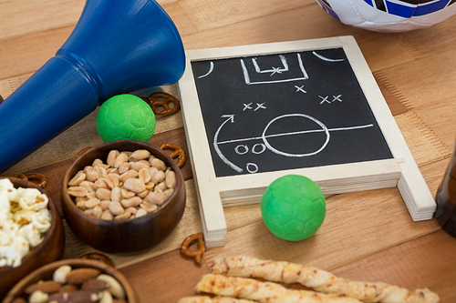 Close-up of strategy board, snacks and balls on wooden table