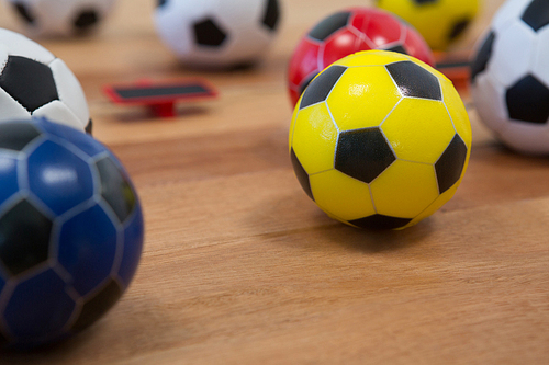 Close-up of various footballs on wooden table