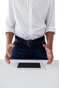 Mid section of teenage boy trying to hold the digital tablet