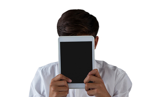 Close-up of teenage boy hiding his face behind digital tablet