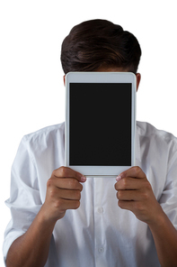 Close-up of teenage boy hiding his face behind digital tablet