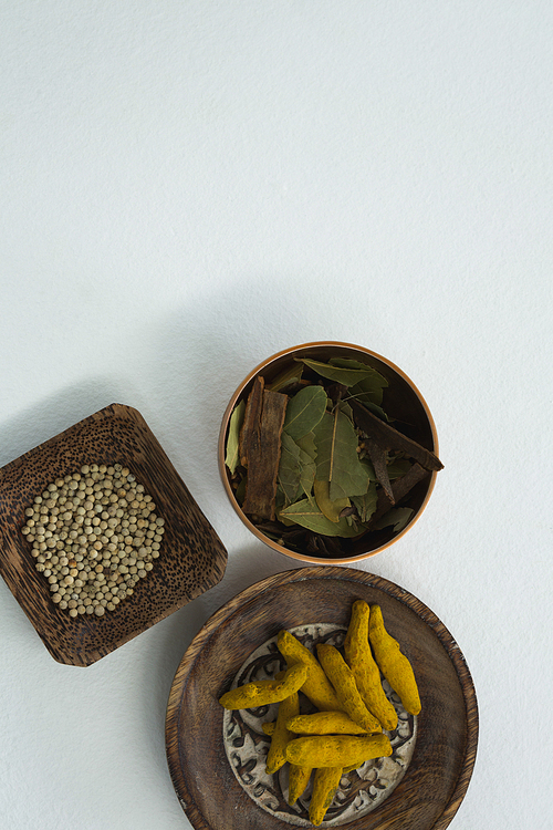 Overhead of turmeric raw seed, bay leaf and seed in bowl