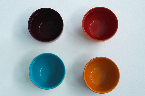 Overhead of colorful empty bowls on white background