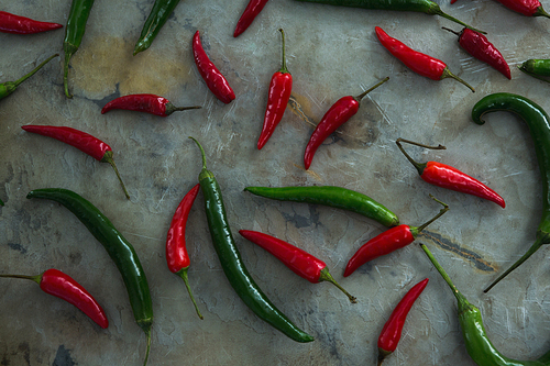 Close-up of green and red chili pepper on table