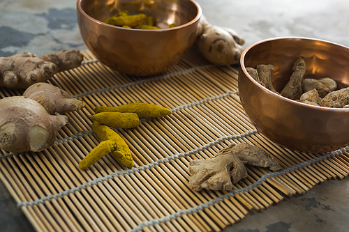 Close-up of ginger and turmeric stick on bamboo placemat