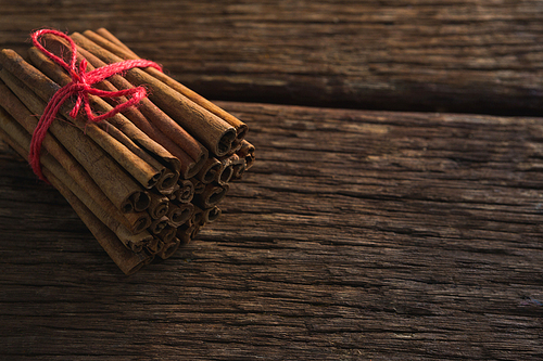 Cinnamon sticks tied with string on wooden table