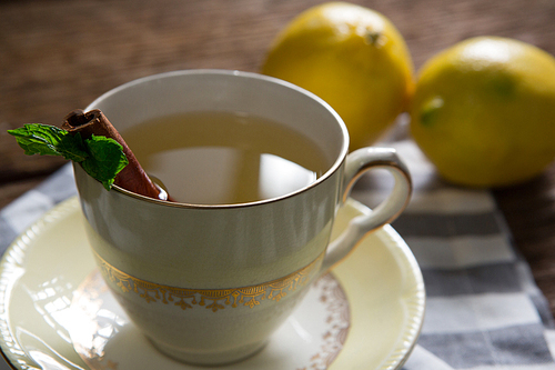 Cup of tea with lemon and cinnamon stick on napkin