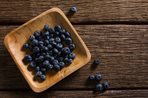 Plate of blueberries on wooden table