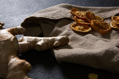 Close-up of ginger and dried orange sliced on textile