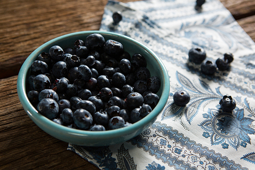 Bowl of blueberries on wooden table