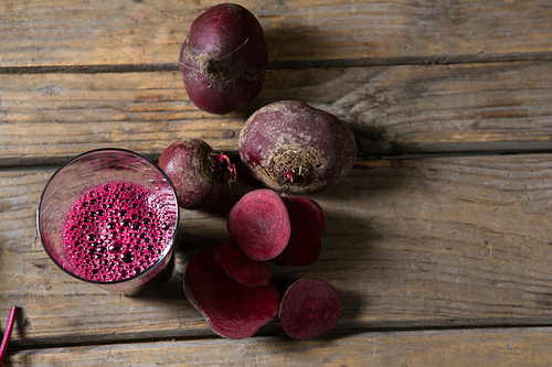 Overhead of beetroot and beetroot juice on wooden table