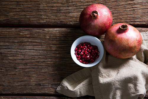 Overhead of pomegranate and napkin on wooden table