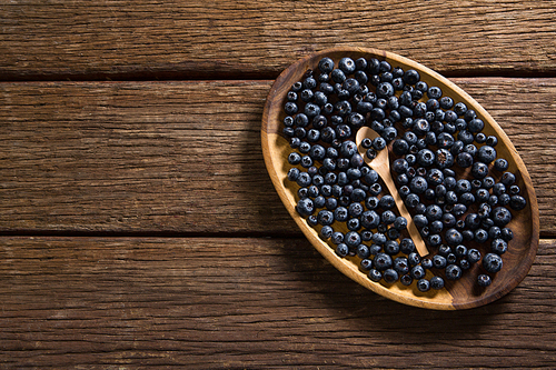 Overhead of blueberries in wooden plate