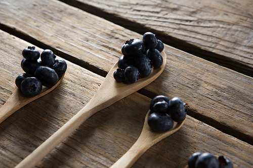 Close-up of blueberries in wooden spoon arranged on table