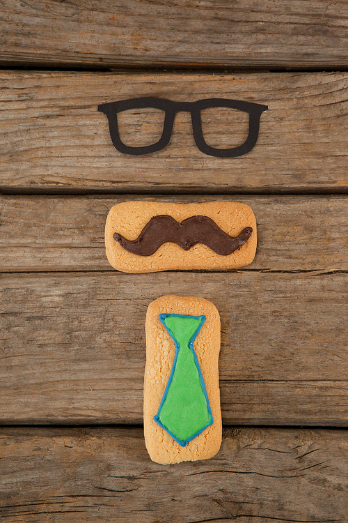 Overhead view of cookies with mustache and tie shape decorataion on wooden table