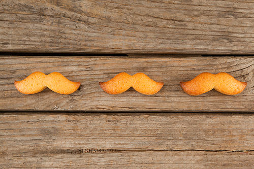 Overhead view of mustache shape cookies on wooden table