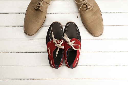 Overhead view of shoes and loafers on wooden white floor