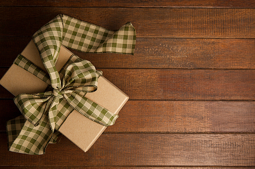 Overhead view of gift box on brown wooden table