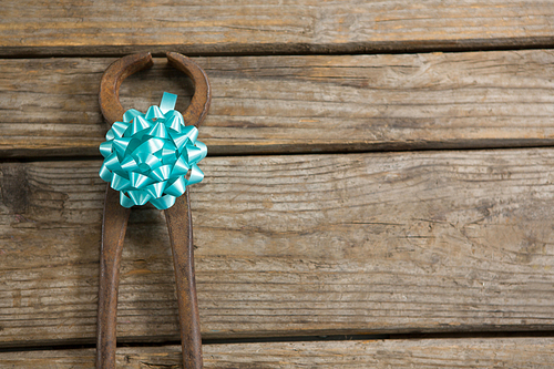 Close up of work tool decorated with ribbon on wooden table