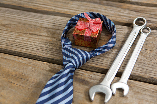 High angle view of gift box with necktie and work tools on table