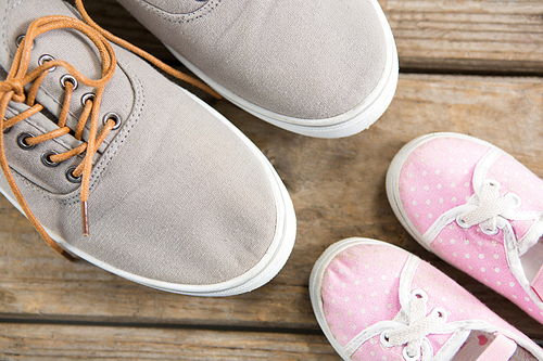 Overhead view of pink and brown shoes on wooden floor