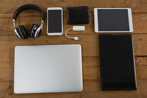 Overhead of various electronic gadgets on wooden plank