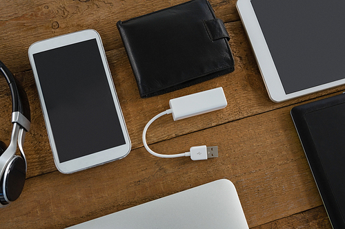 Overhead of various electronic gadgets on wooden plank