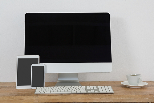 Various electronic gadgets and coffee on table in office