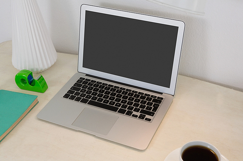 Laptop and office accessories on table in office