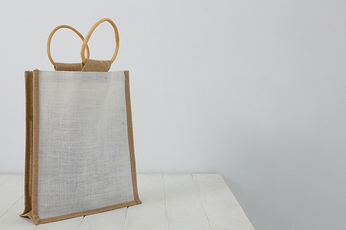 Close-up of bag on table against white wall