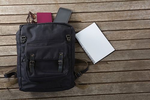 Overhead of vacation bag on wooden plank and accessories on wooden plank